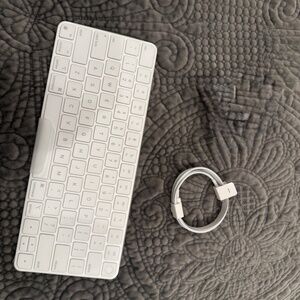 Apple Wireless keyboard in original packaging with charging cord/adapter.